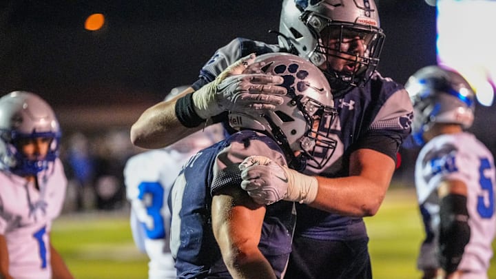 Macomb Dakota Brady Hammy (8) celebrates his touchdown with Justin Bell (72) during the second half of the district finals at Dakota high school in Macomb, Friday, Nov. 8, 2024.