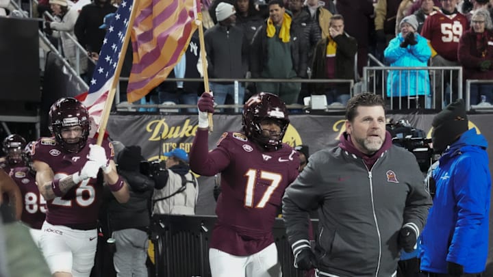 Jan 3, 2025; Charlotte, NC, USA; Virginia Tech Hokies head coach Brent Fry leads his team onto the field during the first quarter against the Minnesota Golden Gophers at the Dukes’ Mayo Bowl at Bank of America Stadium. Mandatory Credit: Jim Dedmon-Imagn Images Jan 3, 2025; Charlotte, NC, USA; Virginia Tech Hokies head coach Brent Fry leads his team onto the field during the first quarter against the Minnesota Golden Gophers at the Dukes’ Mayo Bowl at Bank of America Stadium. Mandatory Credit: Jim Dedmon-Imagn Images