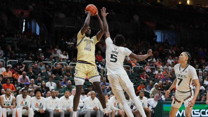 Feb 24, 2024; Coral Gables, Florida, USA; Georgia Tech Yellow Jackets forward Baye Ndongo (11) shoots the basketball over Miami Hurricanes guard Wooga Poplar (5) during the first half at Watsco Center. Mandatory Credit: Sam Navarro-USA TODAY Sports