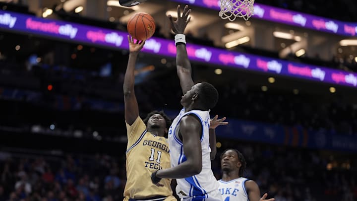 Mar 13, 2025; Charlotte, NC, USA; Georgia Tech Yellow Jackets forward Baye Ndongo (11) goes to the basket against Duke Blue Devils center Khaman Maluach (9) during the first half at Spectrum Center. Mandatory Credit: Jim Dedmon-Imagn Images