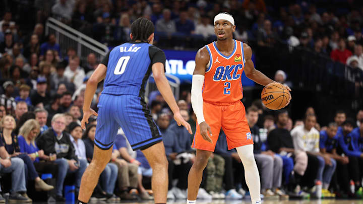 Dec 19, 2024; Orlando, Florida, USA; Oklahoma City Thunder guard Shai Gilgeous-Alexander (2) controls the ball from Orlando Magic guard Anthony Black (0) in the third quarter at Kia Center. Mandatory Credit: Nathan Ray Seebeck-Imagn Images