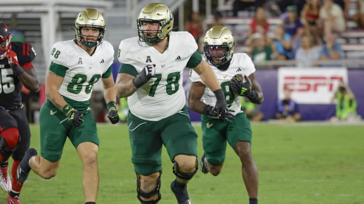 Nov 1, 2024; Boca Raton, Florida, USA;  South Florida Bulls offensive lineman Jack Wilty (78) and tight end Payten Singletary (88) block for running back Kelley Joiner (8) during the second half against the Florida Atlantic Owls at FAU Stadium. Credit: Reinhold Matay-Imagn Images