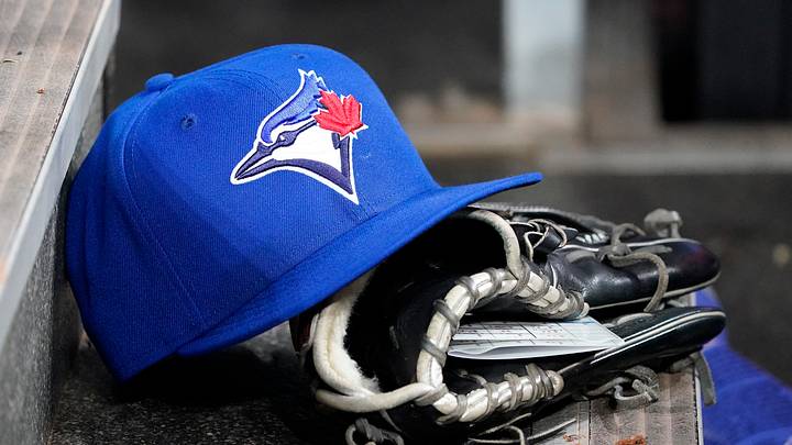A Toronto Blue Jays hat and glove in the dugout. Mandatory Credit: John E. Sokolowski-Imagn Images