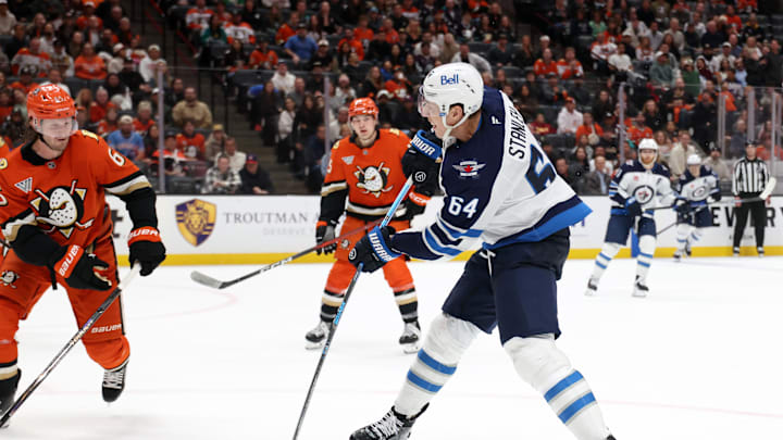 Feb 27, 2026. Winnipeg Jets defenseman Logan Stanley (64) shoots the puck during overtime against the Anaheim Ducks at Honda Center. Mandatory Credit: Kiyoshi Mio-Imagn Images