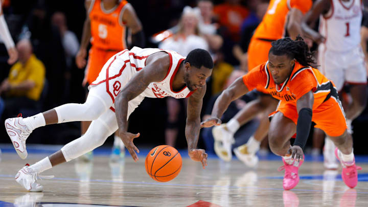Oklahoma Sooners guard Duke Miles (15) and Oklahoma State Cowboys guard Jamyron Keller (14) dive for the ball during a men's college Bedlam basketball game between the University of Oklahoma Sooners (OU) and the Oklahoma State University Cowboys (OSU) at Paycom Center in Oklahoma City, Saturday, Dec. 14, 2024. Oklahoma Sooners guard Duke Miles (15) and Oklahoma State Cowboys guard Jamyron Keller (14) dive for the ball during a men's college Bedlam basketball game between the University of Oklahoma Sooners (OU) and the Oklahoma State University Cowboys (OSU) at Paycom Center in Oklahoma City, Saturday, Dec. 14, 2024.