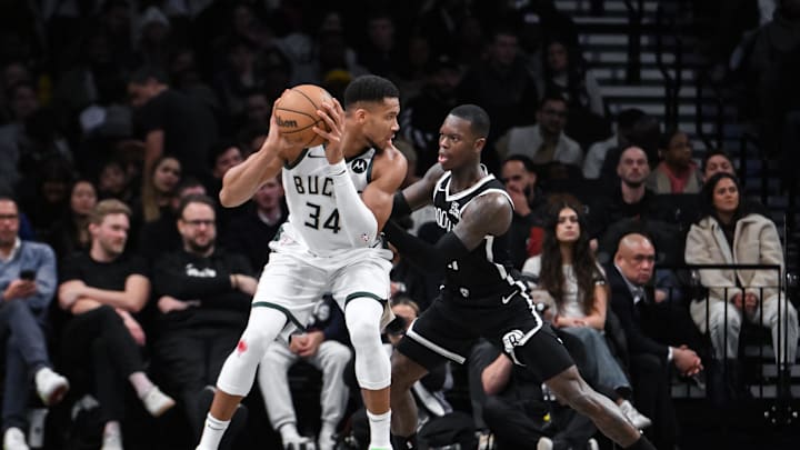 Dec 8, 2024; Brooklyn, New York, USA; Milwaukee Bucks forward Giannis Antetokounmpo (34) posts up against Brooklyn Nets guard Dennis Schroder (17) during the first half at Barclays Center. Mandatory Credit: John Jones-Imagn Images