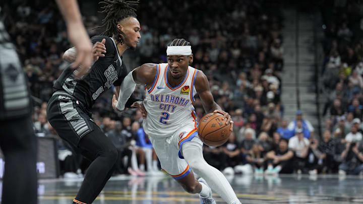 Nov 19, 2024; San Antonio, Texas, USA;  Oklahoma City Thunder guard Shai Gilgeous-Alexander (2) dribbles against San Antonio Spurs guard Stephon Castle (5) in the second half at Frost Bank Center. Mandatory Credit: Daniel Dunn-Imagn Images