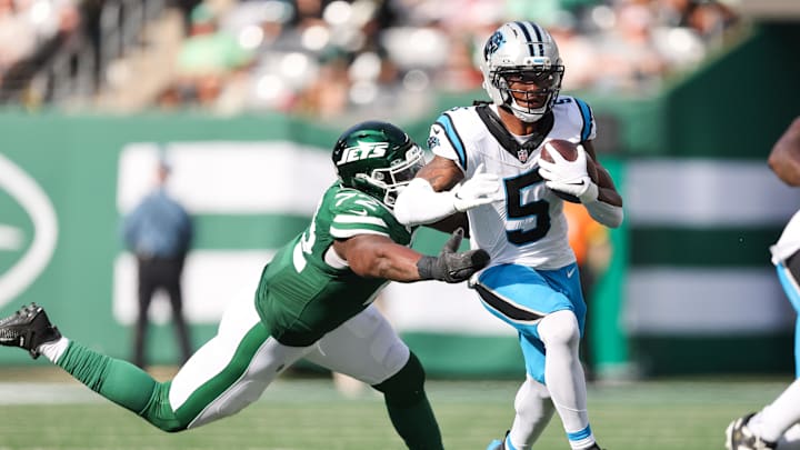 Oct 19, 2025; East Rutherford, New Jersey, USA; Carolina Panthers running back Rico Dowdle (5) runs with the ball while being defended by New York Jets defensive lineman Micheal Clemons (72) in the third quarter at MetLife Stadium. Mandatory Credit: Vincent Carchietta-Imagn Images