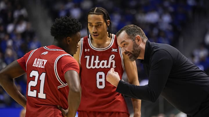 Utah Runnin' Utes head coach Alex Jensen speaks to Utah Utes guard Obomate Abbey (21) forward Keanu Dawes (8) during the first half against the BYU Cougars at Marriott Center.