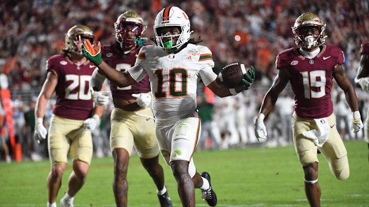 Oct 4, 2025; Tallahassee, Florida, USA; Miami Hurricanes wide receiver Malachi Toney (10) scores a touchdown against Florida State Seminoles defensive back Earl Little Jr. and defensive back Jerry Wilson (19) during the second half at Doak S. Campbell Stadium. Mandatory Credit: Robert Myers-Imagn Images Oct 4, 2025; Tallahassee, Florida, USA; Miami Hurricanes wide receiver Malachi Toney (10) scores a touchdown against Florida State Seminoles defensive back Earl Little Jr. and defensive back Jerry Wilson (19) during the second half at Doak S. Campbell Stadium. Mandatory Credit: Robert Myers-Imagn Images