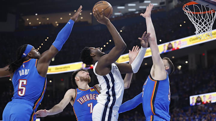 Apr 22, 2025; Oklahoma City, Oklahoma, USA; Memphis Grizzlies forward Jaren Jackson Jr. (13) shoots between Oklahoma City Thunder guard Luguentz Dort (5), forward Chet Holmgren (7), and center Isaiah Hartenstein (55) in the third quarter during game two of first round for the 2024 NBA Playoffs at Paycom Center. Mandatory Credit: Alonzo Adams-Imagn Images