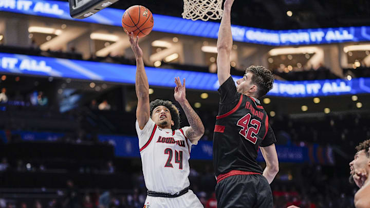 Mar 13, 2025; Charlotte, NC, USA;  Louisville Cardinals guard Chucky Hepburn (24) goes to the basket against Stanford Cardinal forward Maxime Raynaud (42) during the second half at Spectrum Center. Mandatory Credit: Jim Dedmon-Imagn Images