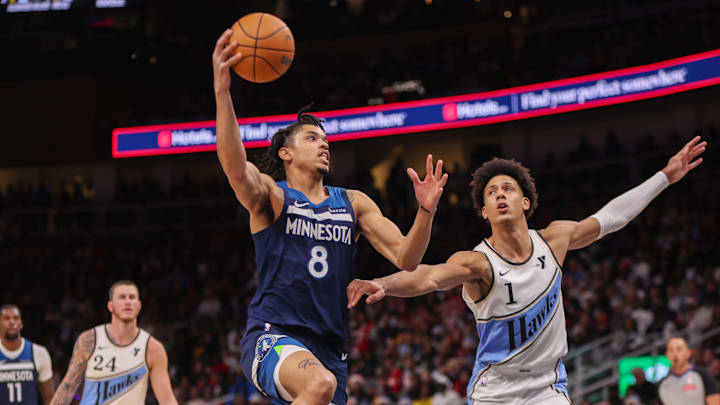 Dec 23, 2024; Atlanta, Georgia, USA; Minnesota Timberwolves forward Josh Minott (8) shoots past Atlanta Hawks forward Jalen Johnson (1) in the fourth quarter at State Farm Arena. Mandatory Credit: Brett Davis-Imagn Images