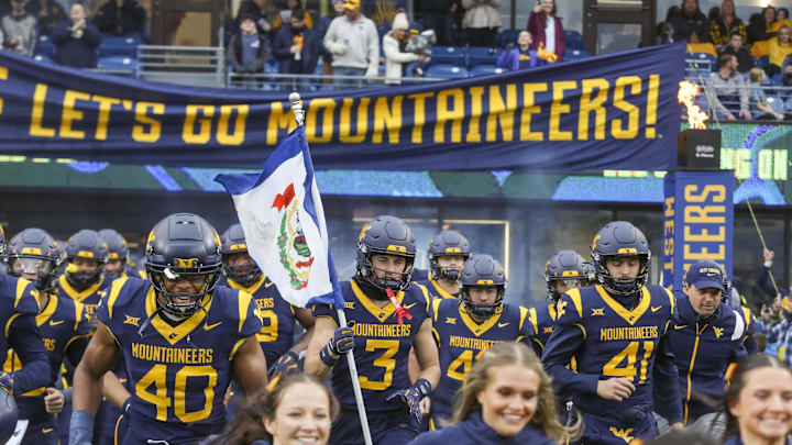Nov 23, 2024; Morgantown, West Virginia, USA; West Virginia Mountaineers wide receiver Hudson Clement (3) carries the West Virginia state flag as he leads his team onto the field before a game against the UCF Knights at Mountaineer Field at Milan Puskar Stadium. Nov 23, 2024; Morgantown, West Virginia, USA; West Virginia Mountaineers wide receiver Hudson Clement (3) carries the West Virginia state flag as he leads his team onto the field before a game against the UCF Knights at Mountaineer Field at Milan Puskar Stadium.