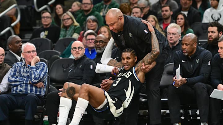 Apr 10, 2025; Milwaukee, Wisconsin, USA; Milwaukee Bucks assistant coach Darlin Ham helps guard Kevin Porter (3) up in the fourth quarter against the New Orleans Pelicans at Fiserv Forum. Mandatory Credit: Benny Sieu-Imagn Images