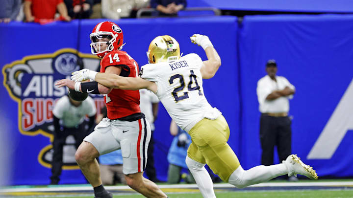 Jan 2, 2025; New Orleans, LA, USA; Georgia Bulldogs quarterback Gunner Stockton (14) controls the ball during the first quarter against Notre Dame Fighting Irish linebacker Jack Kiser (24) at Caesars Superdome. Mandatory Credit: Amber Searls-Imagn Images