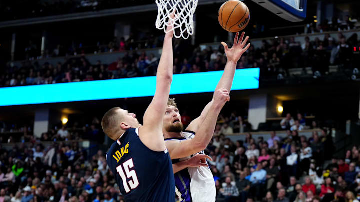 Feb 14, 2024; Denver, Colorado, USA; Sacramento Kings forward Domantas Sabonis (10) shoots the ball over Denver Nuggets center Nikola Jokic (15) in the second half at Ball Arena. Mandatory Credit: Ron Chenoy-USA TODAY Sports