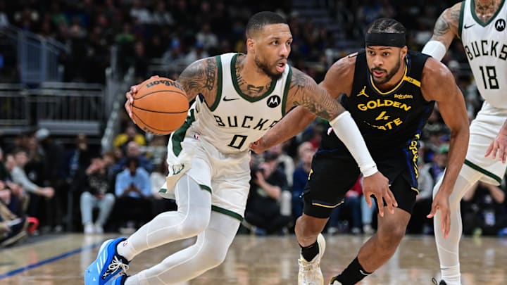 Feb 10, 2025; Milwaukee, Wisconsin, USA; Milwaukee Bucks guard Damian Lillard (0) drives for the basket against Golden State Warriors forward Moses Moody (4) in the third quarter at Fiserv Forum. Mandatory Credit: Benny Sieu-Imagn Images