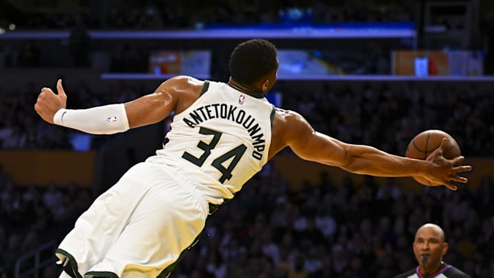 Mar 20, 2025; Los Angeles, California, USA; Milwaukee Bucks forward Giannis Antetokounmpo (34) saves the ball against Los Angeles Lakers center Jaxson Hayes (11) during the first half at Crypto.com Arena. Mandatory Credit: Jonathan Hui-Imagn Images
