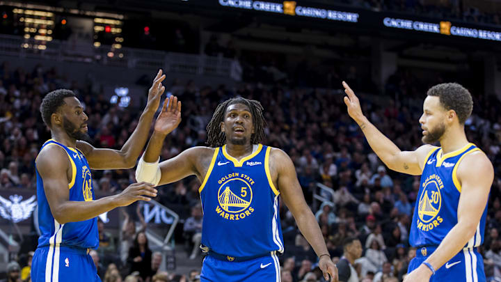 Golden State Warriors forward Andrew Wiggins (22) and guard Kevon Looney (5) and guard Stephen Curry (30) react after drawing a foul against the Denver Nuggets during the first half at Chase Center. 