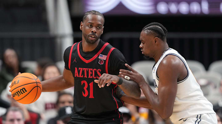 Dec 21, 2024; San Jose, California, USA; San Diego State Aztecs forward Jared Coleman-Jones (31) dribbles against California Golden Bears center Mady Sissoko (right) during the second half at SAP Center. Mandatory Credit: Darren Yamashita-Imagn Images