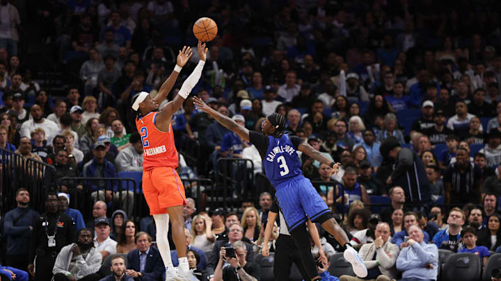Dec 19, 2024; Orlando, Florida, USA; Oklahoma City Thunder guard Shai Gilgeous-Alexander (2) shoots the ball over Orlando Magic guard Kentavious Caldwell-Pope (3) in the second quarter  at Kia Center. Mandatory Credit: Nathan Ray Seebeck-Imagn Images