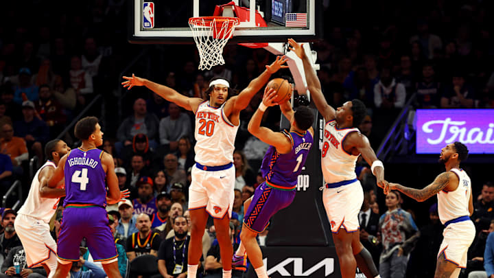 Phoenix Suns guard Devin Booker shoots the ball against New York Knicks center Jericho Sims and forward OG Anunoby.