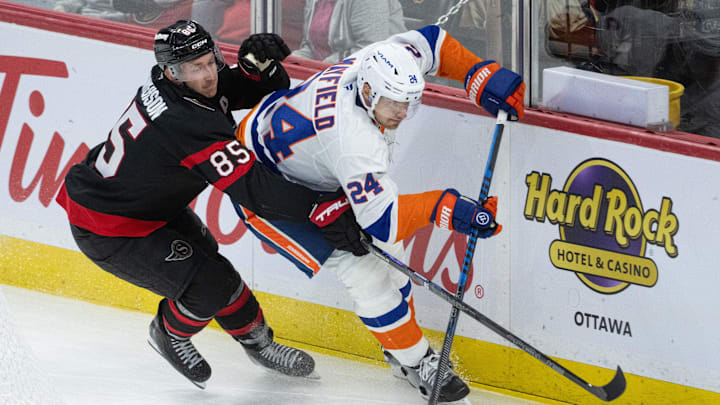 Oct 18, 2025; Ottawa, Ontario, CAN; Ottawa Senators defenseman Jake Sanderson (85) battles with New York Islanders defenseman Scott Mayfield (24) in the third period at the Canadian Tire Centre. Mandatory Credit: Marc DesRosiers-IMAGN Images