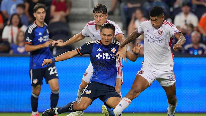 Oct 5, 2024; Cincinnati, Ohio, USA; FC Cincinnati forward Yuya Kubo (7) looks to pass as Orlando City SC midfielder Wilder Cartagena (16) defends during the second half at TQL Stadium. Mandatory Credit: Kareem Elgazzar-Imagn Images