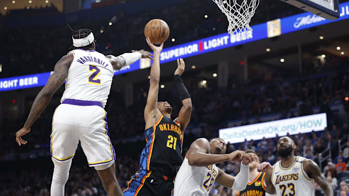 Apr 6, 2025; Oklahoma City, Oklahoma, USA; Oklahoma City Thunder guard Aaron Wiggins (21) goes up for a basket between Los Angeles Lakers forward Jarred Vanderbilt (2) and forward Rui Hachimura (28) during the second half at Paycom Center. Mandatory Credit: Alonzo Adams-Imagn Images
