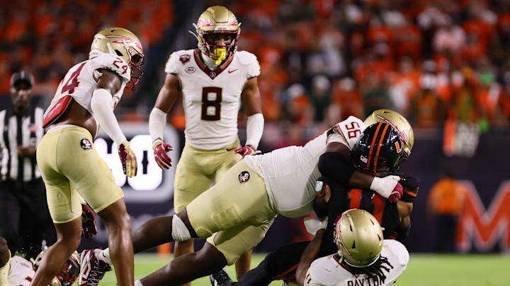 Oct 26, 2024; Miami Gardens, Florida, USA; Florida State Seminoles defensive lineman KJ Sampson (56) tackles Miami Hurricanes wide receiver Samuel Brown (11) during the third quarter at Hard Rock Stadium. Mandatory Credit: Sam Navarro-Imagn Images