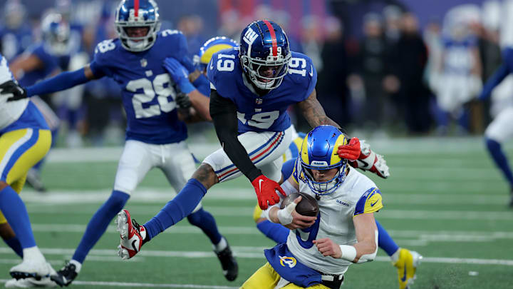 Dec 31, 2023; East Rutherford, New Jersey, USA; Los Angeles Rams quarterback Matthew Stafford (9) is sacked by New York Giants safety Isaiah Simmons (19) during the fourth quarter at MetLife Stadium. Mandatory Credit: Brad Penner-Imagn Images