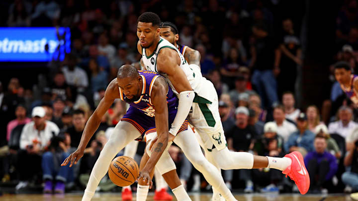 Mar 24, 2025; Phoenix, Arizona, USA; Phoenix Suns forward Kevin Durant (35) and Milwaukee Bucks forward Giannis Antetokounmpo (34) go for the ball during the fourth quarter at Footprint Center. Mandatory Credit: Mark J. Rebilas-Imagn Images