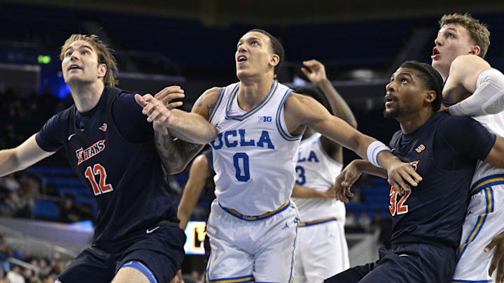 Nov 22, 2024; Los Angeles, California, USA; Cal State Fullerton Titans center Zachary Visentin (12), forward John Mikey Square (32), UCLA Bruins guard Kobe Johnson (0), forward Tyler Bilodeau (34) jockey for rebounding position during the second half at Pauley Pavilion presented by Wescom. Mandatory Credit: Robert Hanashiro-Imagn Images