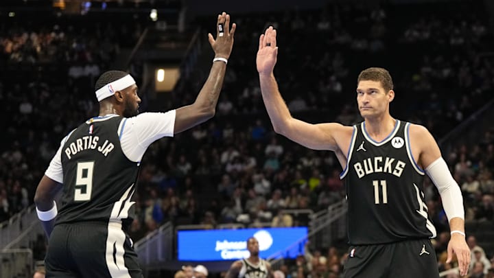 Nov 12, 2024; Milwaukee, Wisconsin, USA;  Milwaukee Bucks center Brook Lopez (11) high five forward Bobby Portis (9) during the second quarter against the Toronto Raptors at Fiserv Forum. Mandatory Credit: Jeff Hanisch-Imagn Images