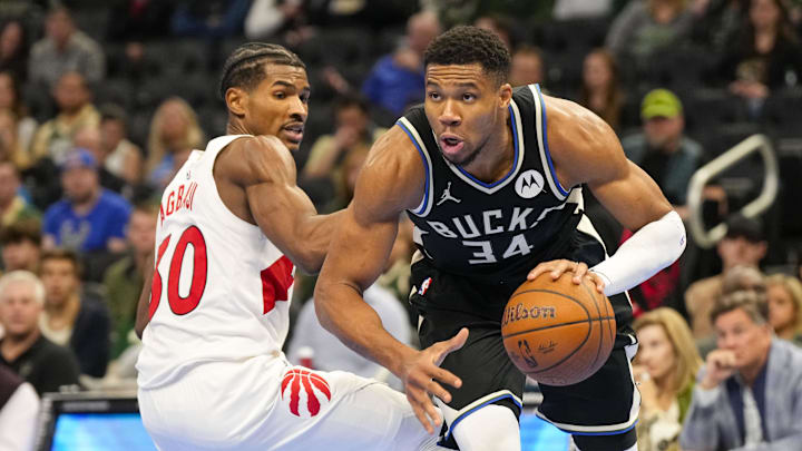Nov 12, 2024; Milwaukee, Wisconsin, USA;  Milwaukee Bucks forward Giannis Antetokounmpo (34) drives for the basket around Toronto Raptors guard Ochai Agbaji (30) during the fourth quarter at Fiserv Forum. Mandatory Credit: Jeff Hanisch-Imagn Images