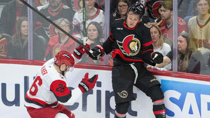 Apr 25, 2026; Ottawa, Ontario, CAN; Carolina Hurricanes defenseman Sean Walker (26) and  Ottawa Senators center Tim Stutzle (18) battle for the puck in the third period of game four of the first round of the 2026 Stanley Cup Playoffs at the Canadian Tire Centre. Mandatory Credit: Marc DesRosiers-Imagn