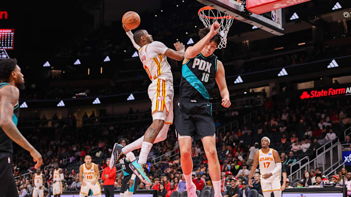 Mar 1, 2026; Atlanta, Georgia, USA; Atlanta Hawks forward Jonathan Kuminga (0) dunks over Portland Trail Blazers center Yang Hansen (16) in the fourth quarter at State Farm Arena. Mandatory Credit: Brett Davis-Imagn Images
