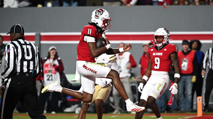 Nov 1, 2025; Raleigh, North Carolina, USA; North Carolina State Wolfpack quarter back CJ Bailey (11) scores a touchdown against the Georgia Tech Yellow Jackets during the first quarter at Carter-Finley Stadium. Mandatory Credit: Zachary Taft-Imagn Images Nov 1, 2025; Raleigh, North Carolina, USA; North Carolina State Wolfpack quarter back CJ Bailey (11) scores a touchdown against the Georgia Tech Yellow Jackets during the first quarter at Carter-Finley Stadium. Mandatory Credit: Zachary Taft-Imagn Images