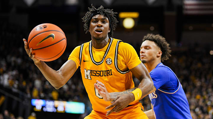 Dec 8, 2024; Columbia, Missouri, USA; Missouri Tigers guard Anthony Robinson II (0) grabs a loose ball against Kansas Jayhawks guard Zeke Mayo (5) during the first half at Mizzou Arena. Mandatory Credit: Jay Biggerstaff-Imagn Images