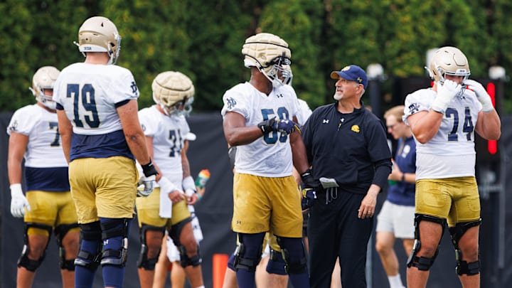 Notre Dame offensive line coach Joe Rudolph, second from right, talks to offensive lineman Aamil Wagner (59) during a Notre Dame football practice at Irish Athletic Center on Thursday, Aug. 1, 2024, in South Bend.