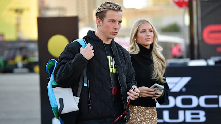 Nov 21, 2024; Las Vegas, Nevada, USA; Visa Cash App RB driver Liam Lawson (30) arrives with girlfriend Hannah St. John before practice for the Las Vegas Grand Prix at Las Vegas Circuit. Mandatory Credit: Gary A. Vasquez-Imagn Images