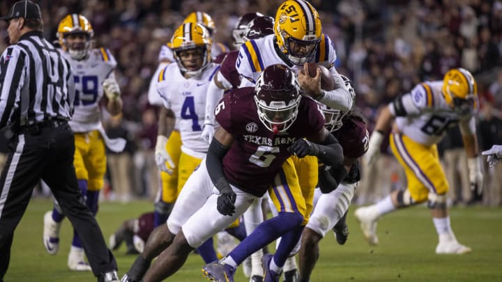 Nov 26, 2022; College Station, Texas, USA; LSU Tigers quarterback Jayden Daniels (5) and Texas A&M Aggies defensive lineman Enai White (6) in action during the game between the Texas A&M Aggies and the LSU Tigers at Kyle Field. Mandatory Credit: Jerome Miron-USA TODAY Sports Nov 26, 2022; College Station, Texas, USA; LSU Tigers quarterback Jayden Daniels (5) and Texas A&M Aggies defensive lineman Enai White (6) in action during the game between the Texas A&M Aggies and the LSU Tigers at Kyle Field. Mandatory Credit: Jerome Miron-USA TODAY Sports