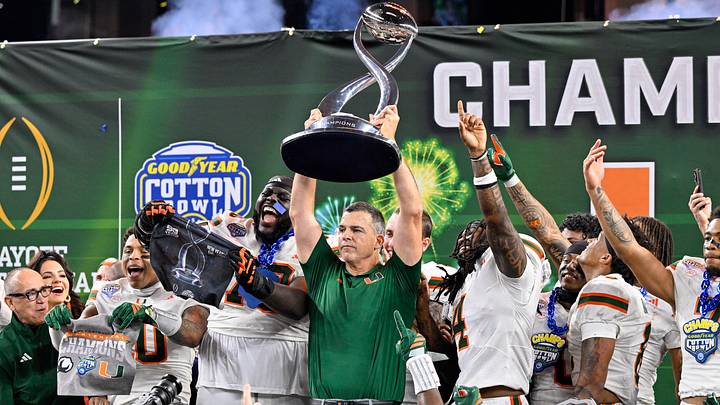 Dec 31, 2025; Arlington, TX, USA; Miami Hurricanes head coach Mario Cristobal hoists the trophy as he celebrates with his team after the 2025 Cotton Bowl and quarterfinal game of the College Football Playoff at AT&T Stadium. Mandatory Credit: Jerome Miron-Imagn Images