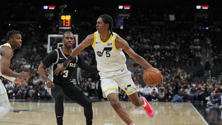 Nov 9, 2024; San Antonio, Texas, USA;  Utah Jazz forward Cody Williams (5) dribbles past San Antonio Spurs guard Chris Paul (3) in the first half at Frost Bank Center. Mandatory Credit: Daniel Dunn-Imagn Images
