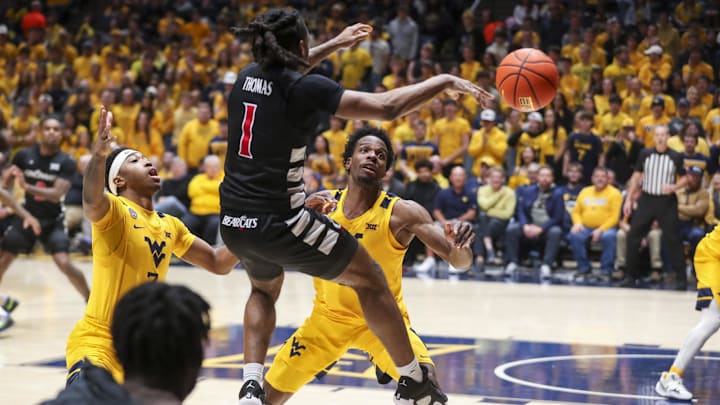 Feb 19, 2025; Morgantown, West Virginia, USA; West Virginia Mountaineers guard KJ Tenner (3) and West Virginia Mountaineers guard Toby Okani (5) defend Cincinnati Bearcats guard Day Day Thomas (1) during the second half at WVU Coliseum. Mandatory Credit: Ben Queen-Imagn Images Feb 19, 2025; Morgantown, West Virginia, USA; West Virginia Mountaineers guard KJ Tenner (3) and West Virginia Mountaineers guard Toby Okani (5) defend Cincinnati Bearcats guard Day Day Thomas (1) during the second half at WVU Coliseum. Mandatory Credit: Ben Queen-Imagn Images