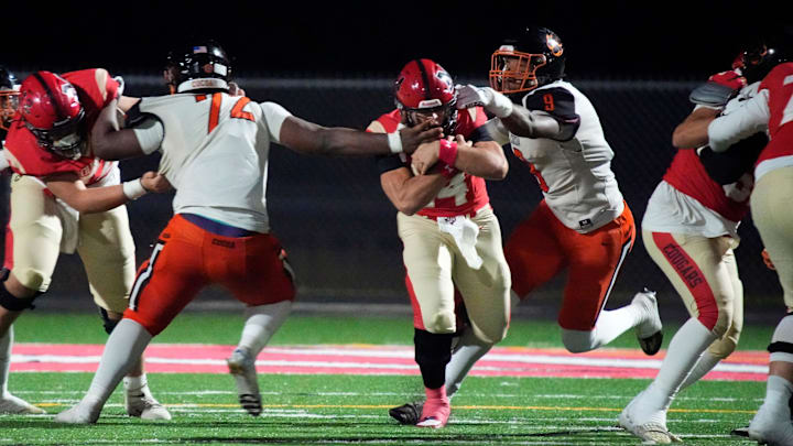 Cocoa High defenders Chavez Thompson (#72) and Javion Hilson (#9) close in on Cardinal Mooney quarterback Devin Mignery (#14) on a quarterback keeper. Cocoa High School defeated Cardinal Mooney Catholic High School 31-21 to win the Class 2A semi-final game Friday night in Sarasota. Cocoa High defenders Chavez Thompson (#72) and Javion Hilson (#9) close in on Cardinal Mooney quarterback Devin Mignery (#14) on a quarterback keeper. Cocoa High School defeated Cardinal Mooney Catholic High School 31-21 to win the Class 2A semi-final game Friday night in Sarasota.