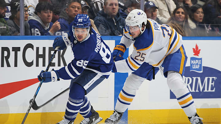Toronto Maple Leafs Nicholas Robertson protecting the puck from Buffalo Sabres 2021 first overall pick Owen Power