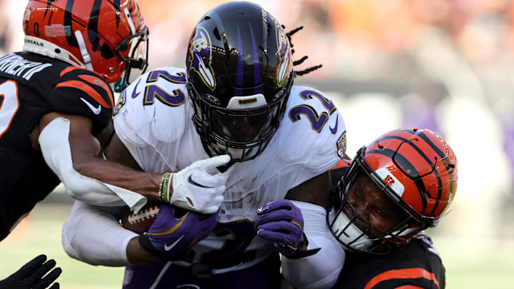 Oct 6, 2024; Cincinnati, Ohio, USA; Baltimore Ravens running back Derrick Henry (22) runs the ball as Cincinnati Bengals defensive end Myles Murphy (99) makes the tackle during the second half at Paycor Stadium. Mandatory Credit: Joseph Maiorana-Imagn Images