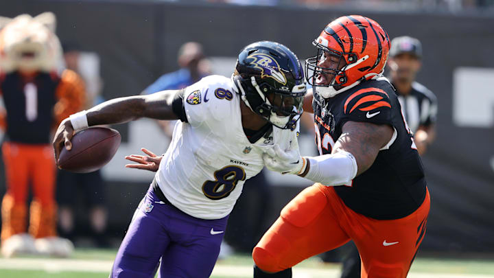 Baltimore Ravens quarterback Lamar Jackson escapes the pressure from Cincinnati Bengals defensive tackle B.J. Hill